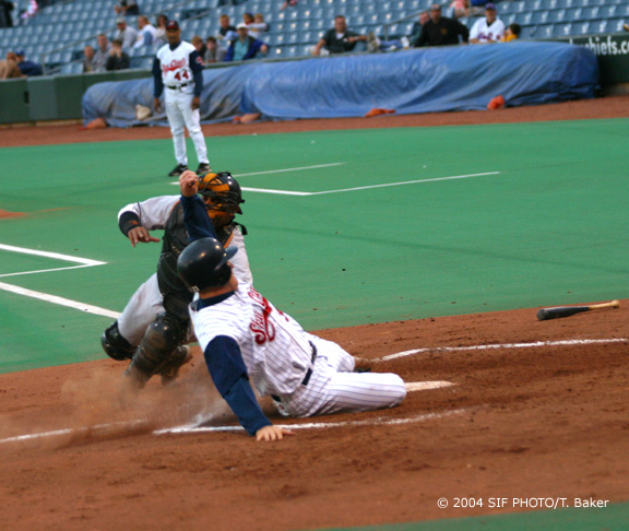 (Pictured) Syracuse Skychief Gabe Gross slides into home and eludes the tag of the Ottawa Lynx catcher Geromino Gil during the 4th inning of Thursday's game. The Skychiefs won 13-8.