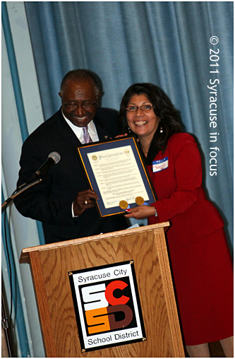 Council President Van Robinson presents a city proclamation to on-air personality Fanny Villarreal during the Hispanic Heritage Month yesterday at Delaware Academy.