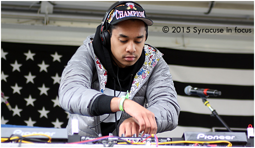 Ayo Alex warms his hands on the wheels at Walnut Park (May Fest).