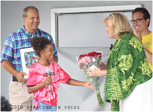 Marilyn Higgins was given an award today during the Near Westside Initiative's Multicultural Block Party today. She  was also serenaded for her birthday. She accepted a bouquet by a student during ceremony and was joined on stage by  Near Westside executives Robert Daino  (left) and Marteen Jacobs. 