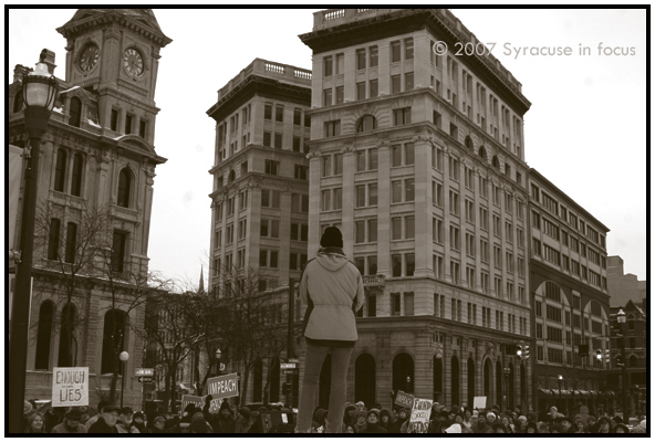Jan. 27--About 100 people gathered in Clinton Square to protest the war in Iraq and President Bush's proposed troop increase. The rally was held in support of a larger rally held in Washington, DC.  Standing atop a pillar, Syracuse Peace Council member Jessica Maxwell addresses the crowd.